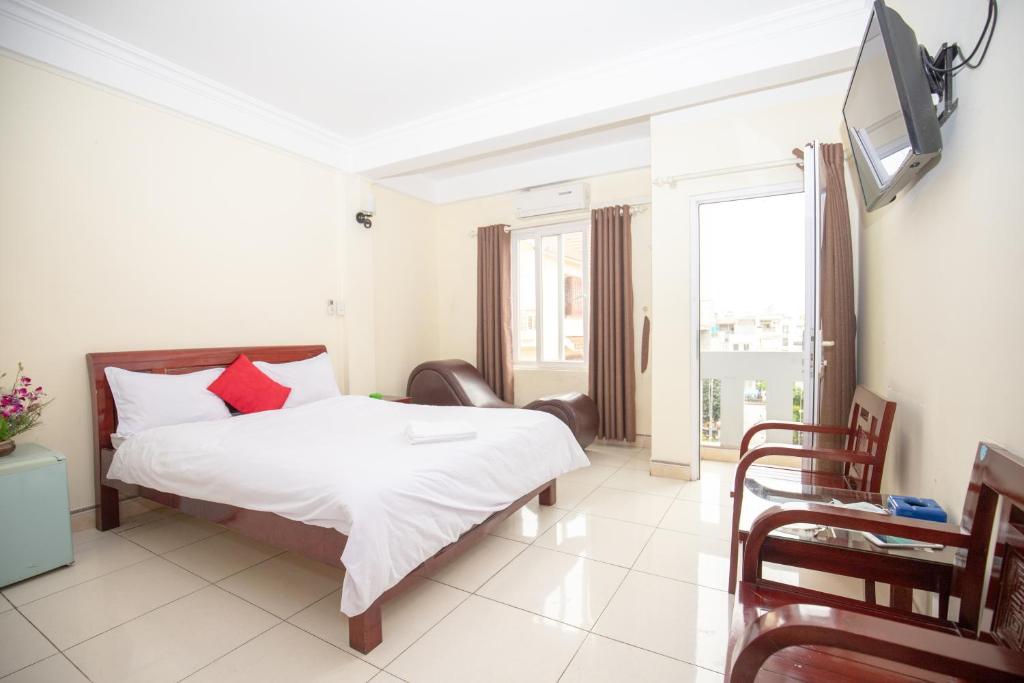 海防Ngoc Ha Hotel 2的一间卧室配有一张床,墙上配有电视