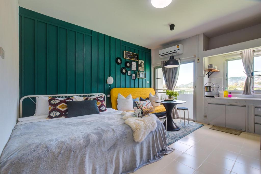 查汶查汶公寓的一间卧室设有一张床和绿色的墙壁