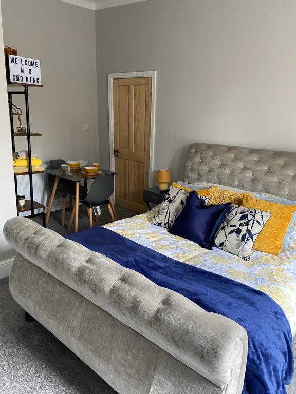 滨海圣安娜Cambridge Villas Private Studio Lytham St Annes的一间卧室配有一张带蓝色毯子的大床
