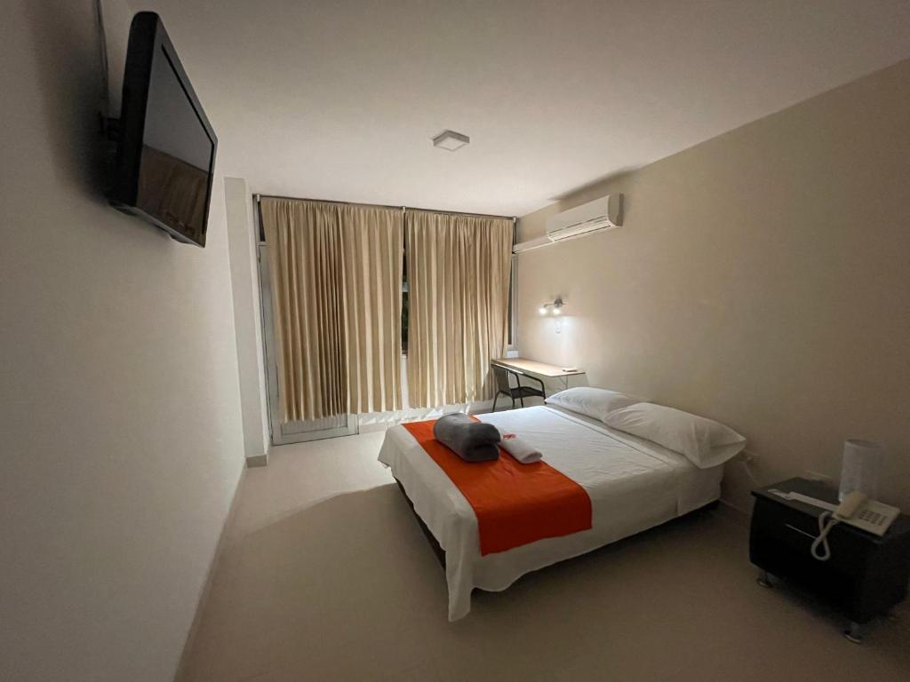 约帕尔Hotel Luna Roja del Llano的一间卧室配有一张床和一台电视