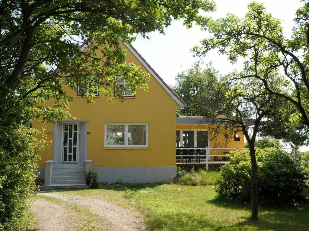 博利尔马克10 person holiday home in R m的前面有车道的黄色房子
