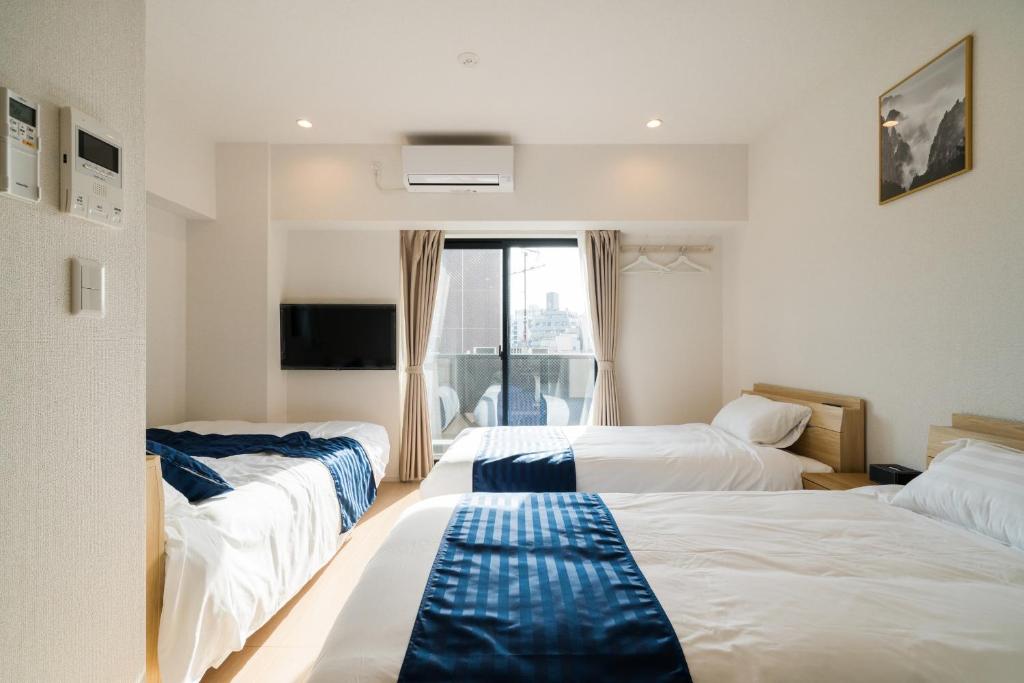 东京Hotel Emir的酒店客房设有三张床和窗户。