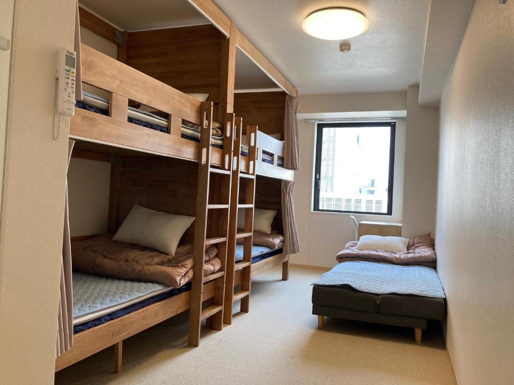 东京Tokyo Ueno Youth Hostel的双层床间 - 带两张双层床和椅子