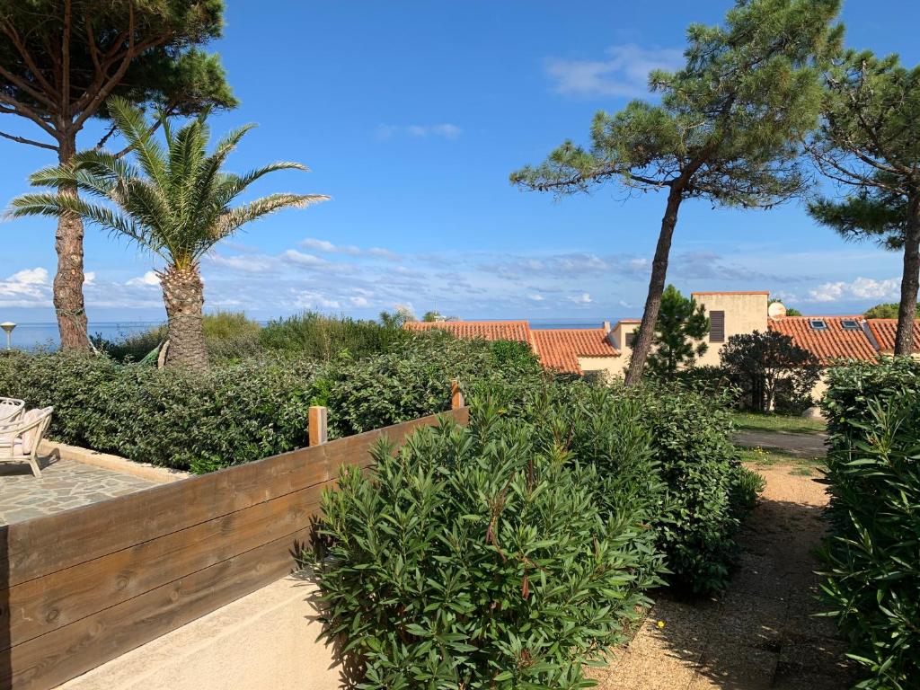 卢米奥Mini villa climatisée - Vue mer - Mer à 50 m - Jardin et 2 terrasses 300 m2的树丛和树丛前的木栅