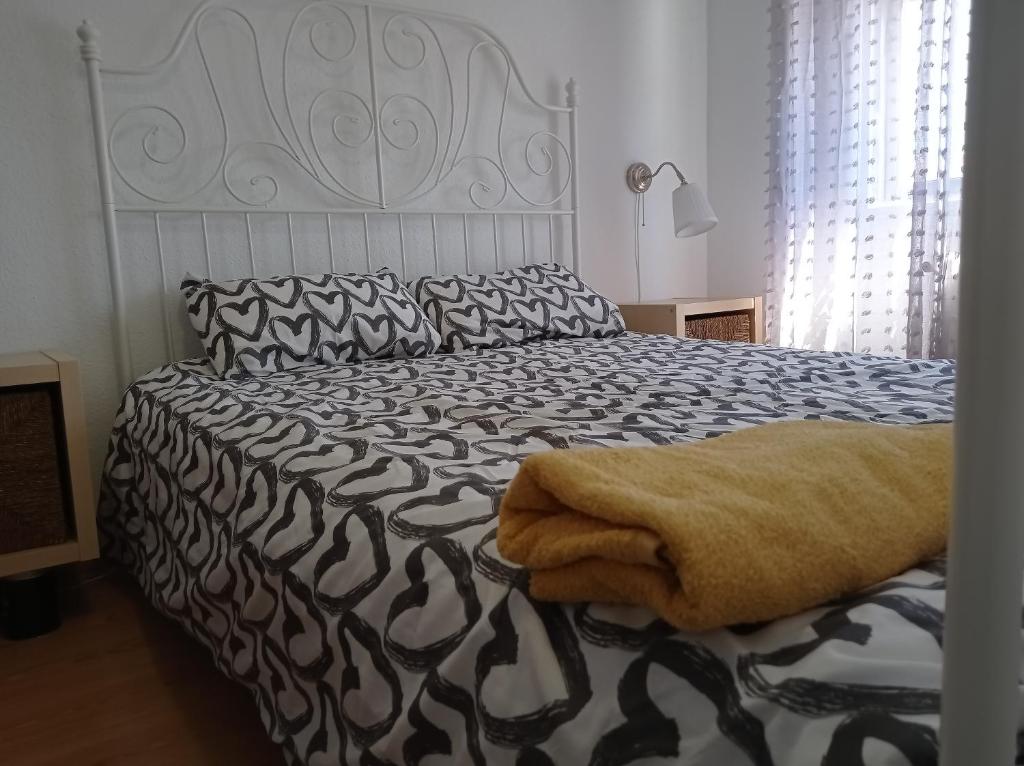 巴利亚多利德Apartamento TISARE wifi的一间卧室配有一张带黑白色棉被的床