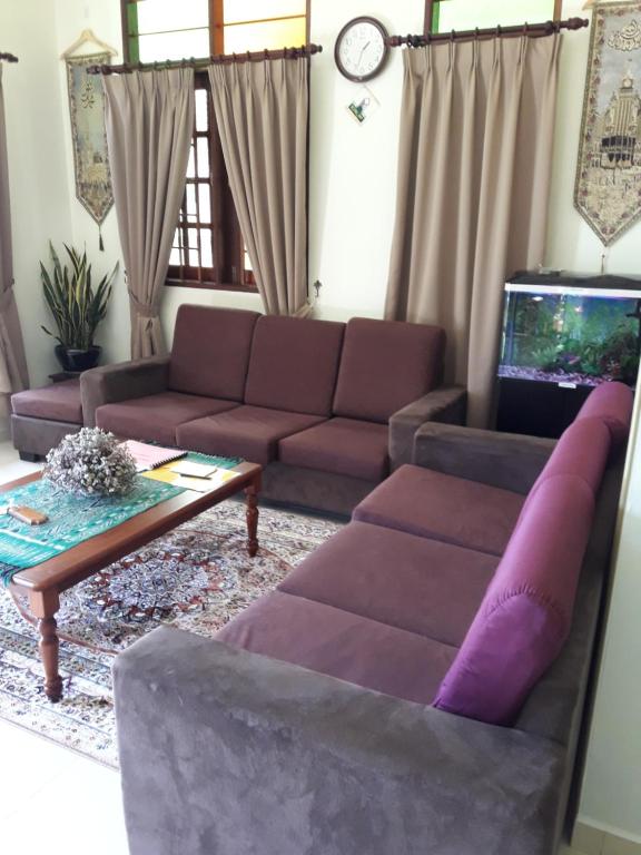 龙运Anjung Nor Muslim Homestay的带沙发和咖啡桌的客厅