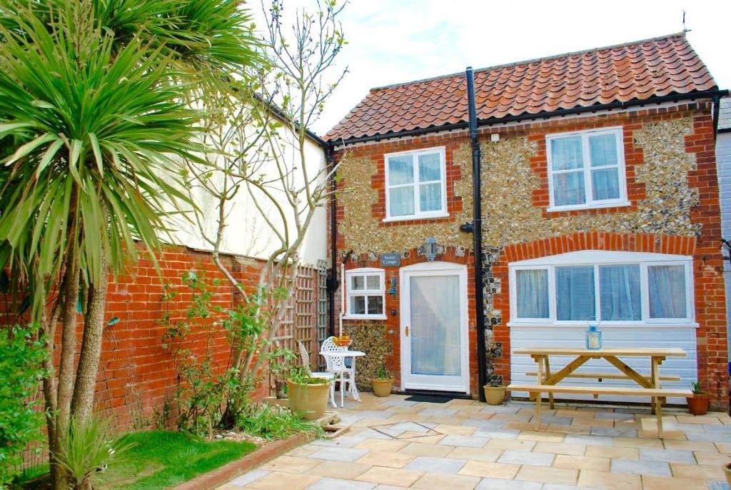 萨克斯曼德姆Romantic Flint Cottage on the Suffolk Coast的砖屋,前面设有野餐桌