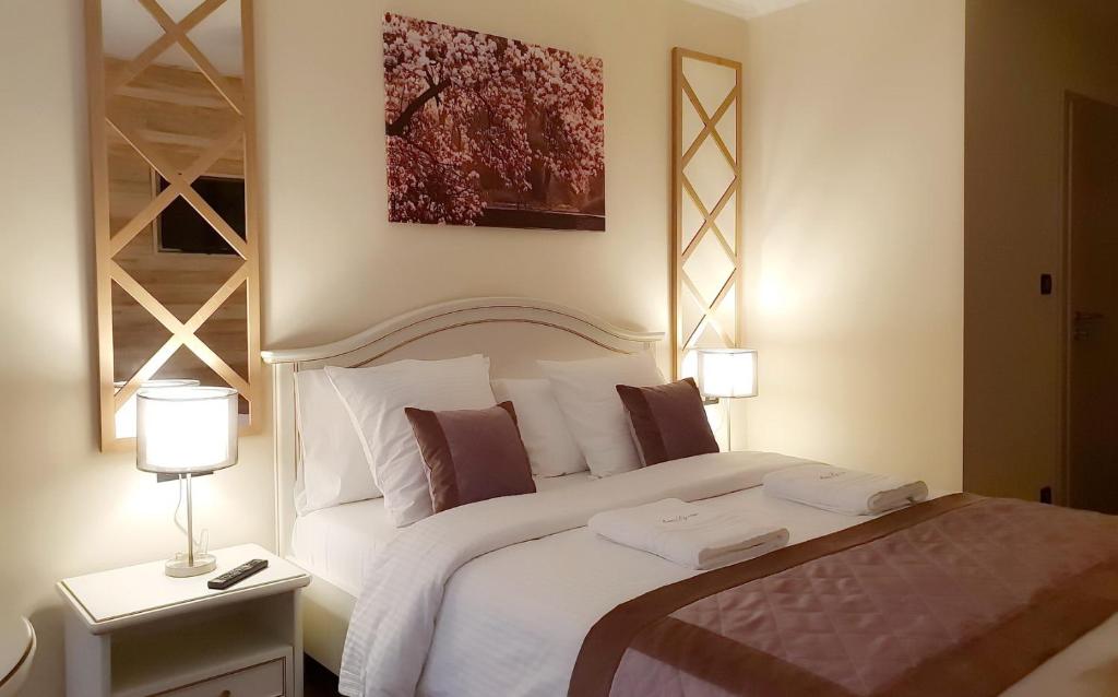 富伦B&B Secret Garden的一间卧室配有一张带两盏灯的大型白色床。
