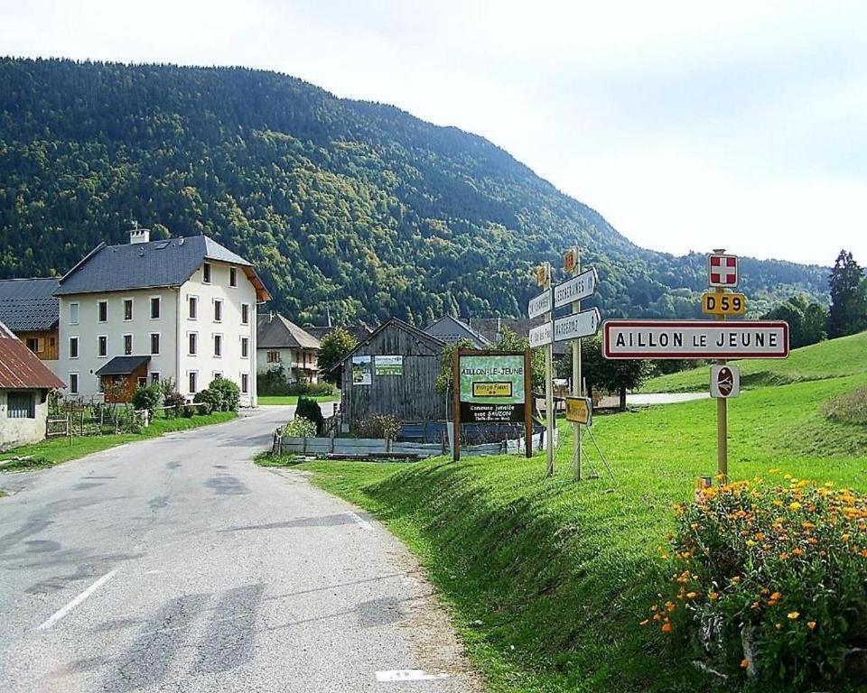 Aillon-le-JeuneHôtel du Soleil的带有街道标志的村庄和山