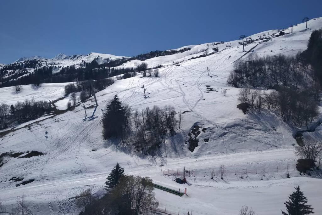 勒克比尔Studio 4pers vue piste的雪覆盖的斜坡,人们滑雪下山