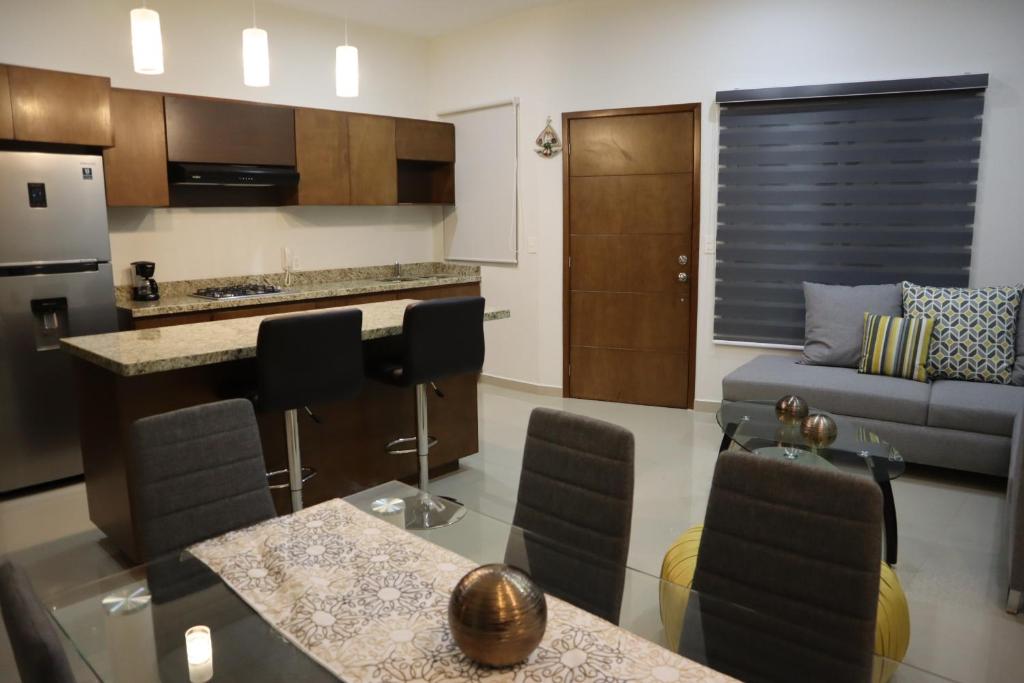 马萨特兰Departamento nuevo a 3 min de la playa的厨房以及带沙发和桌子的客厅。