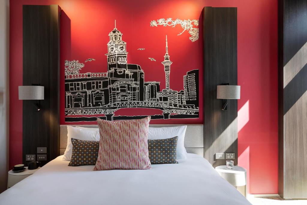 奥克兰Mercure Auckland Queen Street的一间卧室设有一张红色墙壁的大床