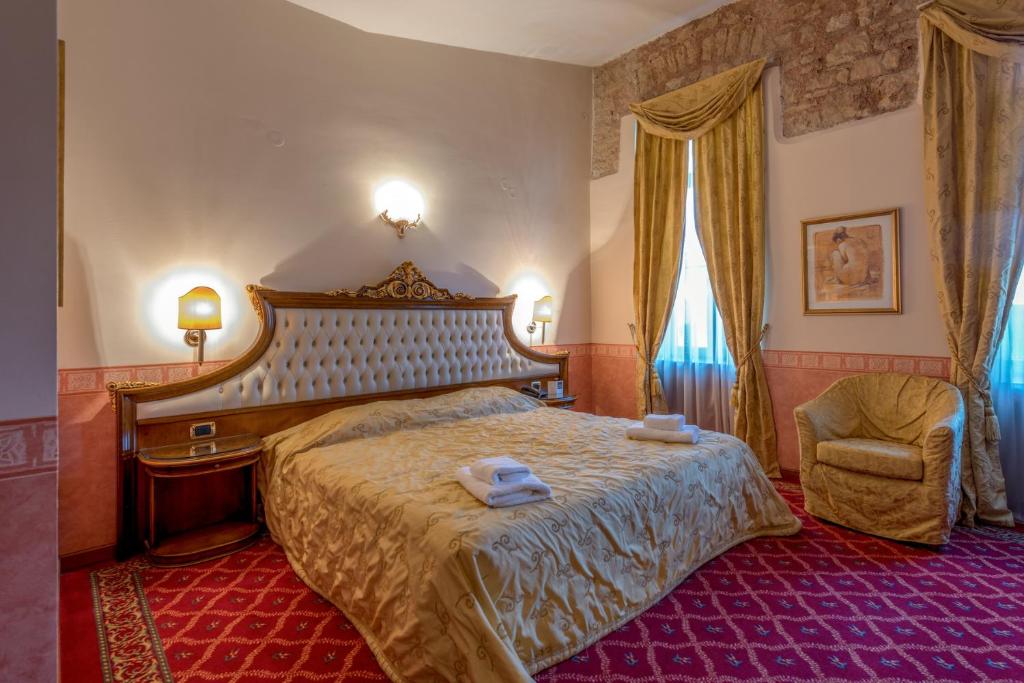 约阿尼纳阿莱索斯豪华酒店的一间卧室配有一张大床和一把椅子