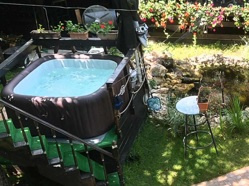 Cornu de JosVila Ralf的花园内的热水浴池,种植了植物,配有椅子