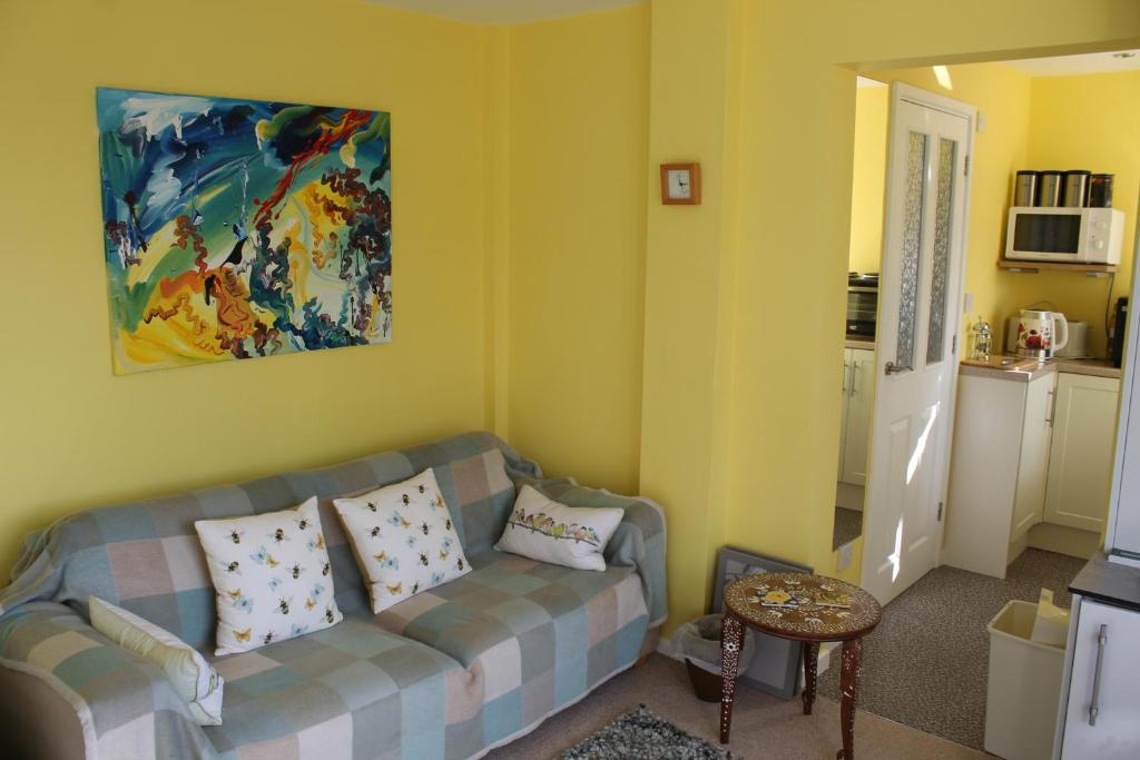 WestcottThe Garden Room Westcott的客厅配有沙发和墙上的绘画