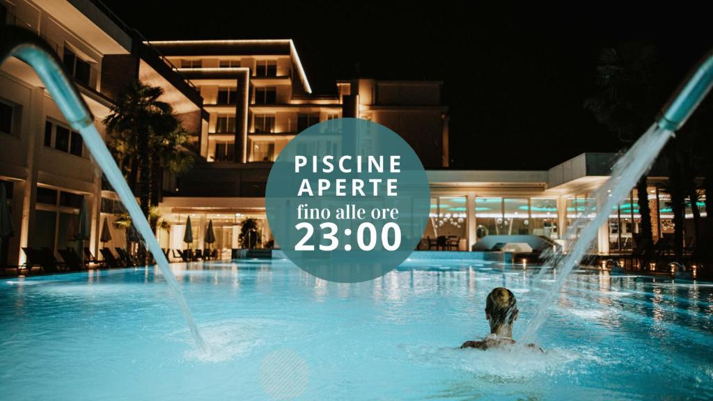 阿巴诺泰尔梅威尼斯温泉酒店的水中标牌的游泳池里的人
