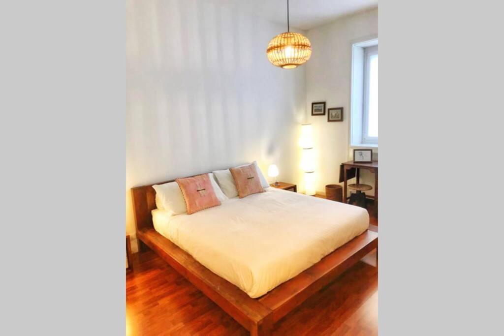 贝加莫“Dietro l’angolo” Charme & Relax nel centro città的一间卧室配有一张床和一个吊灯