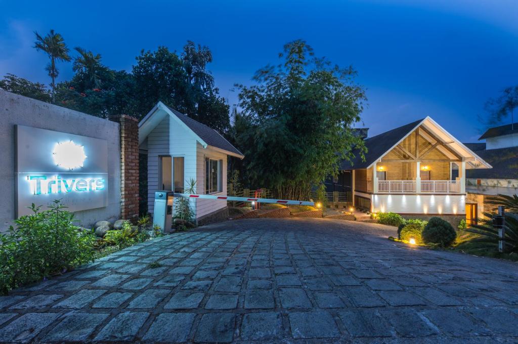 蒙纳Trivers Resort Munnar的夜间在房子前面的车道
