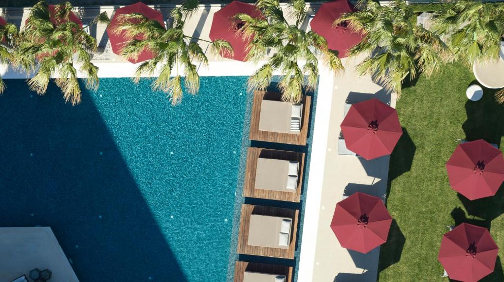 科斯镇水蓝精品酒店及水疗中心 - 仅限成人 - 世界小型豪华酒店的享有带红伞的游泳池的顶部景致