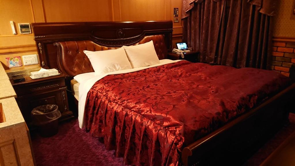 川口市Hotel Zips (Adult Only)的一间卧室配有一张带红色毯子的大床
