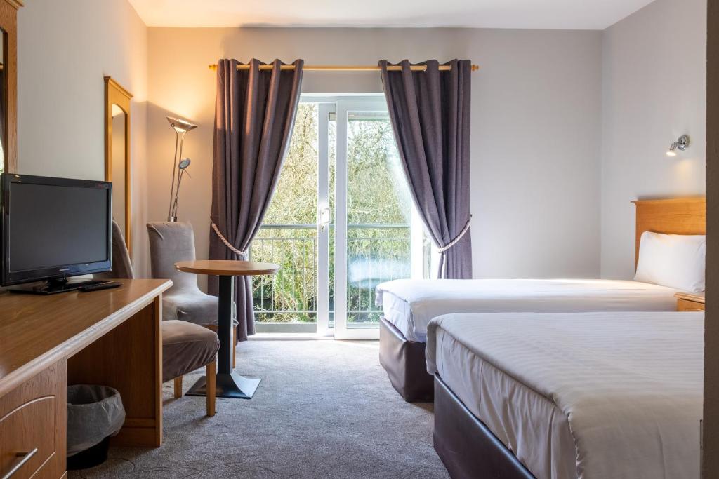 阿克洛The Lodge at Woodenbridge的酒店客房设有两张床和电视。