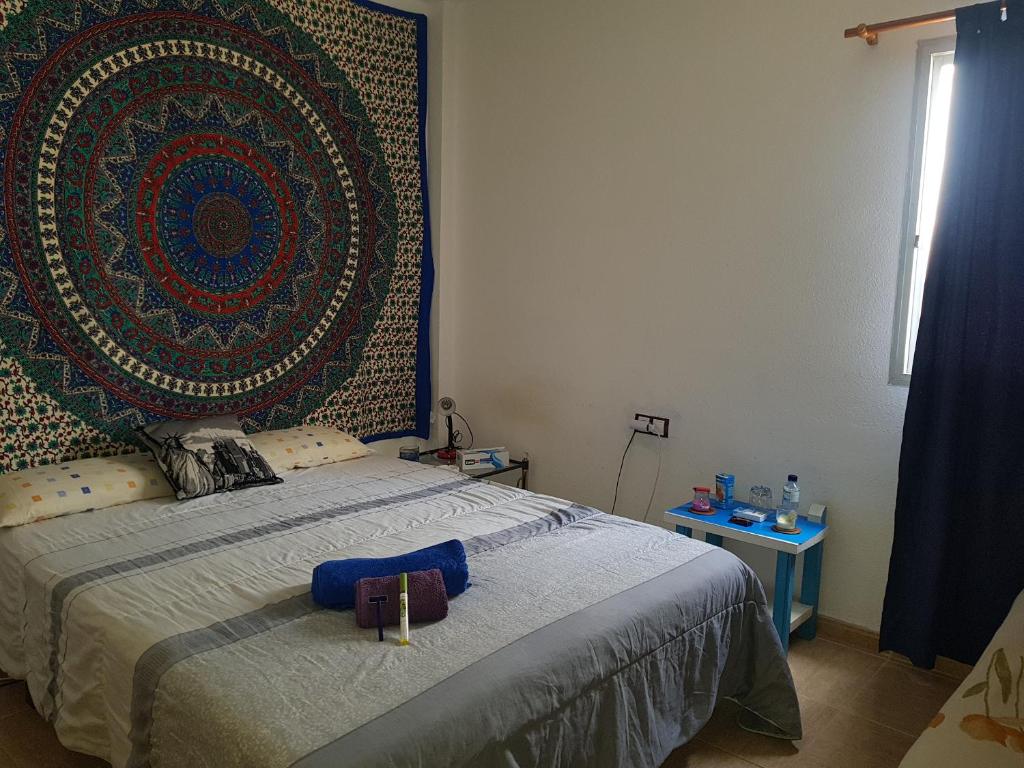 罗萨里奥港laurainu的卧室配有一张床铺,墙上挂着大挂毯