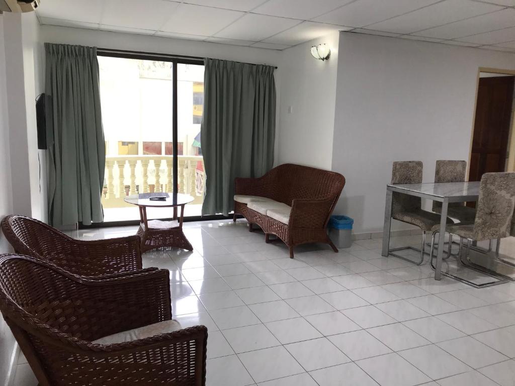 邦咯Pangkor Coralbay Resort 201 apartment的客厅配有椅子、桌子和窗户