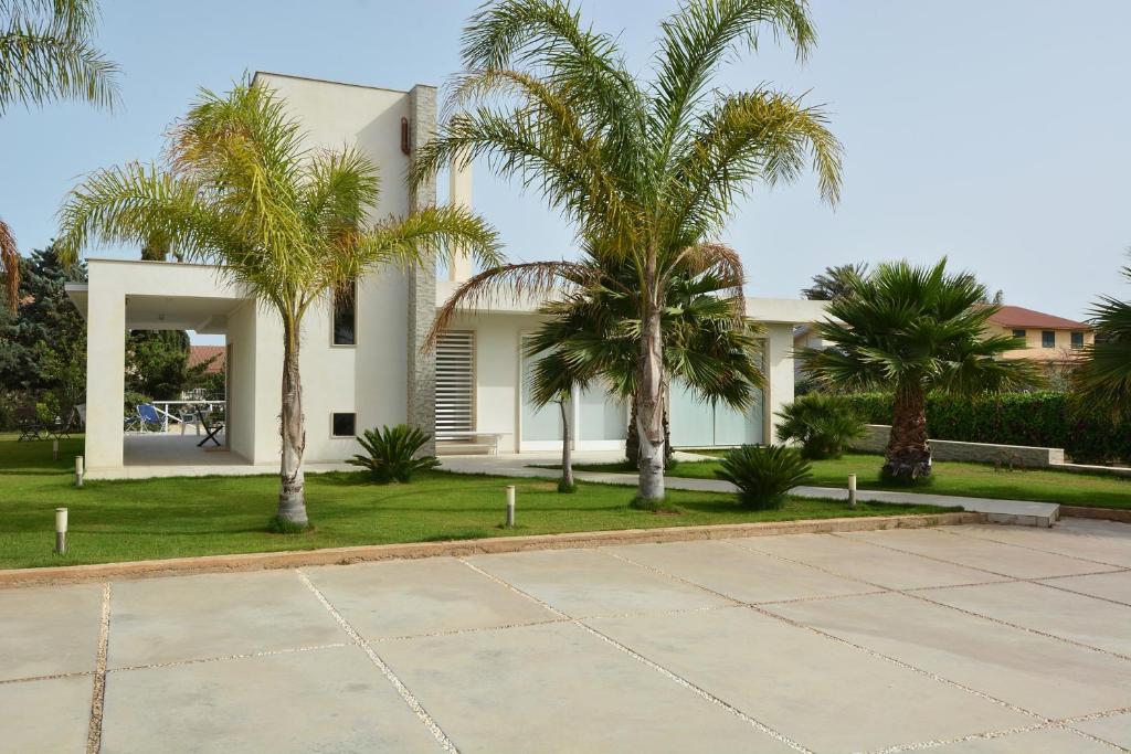 塞卡角Villa del Gelsomino的前面有棕榈树的房子