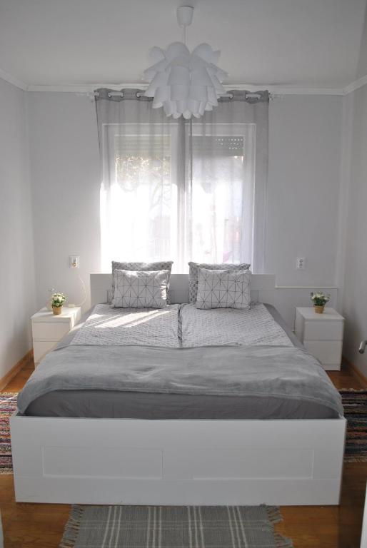 奥巴曹洛克Rózsa Vendégház的白色卧室内的一张大白色床,配有吊灯