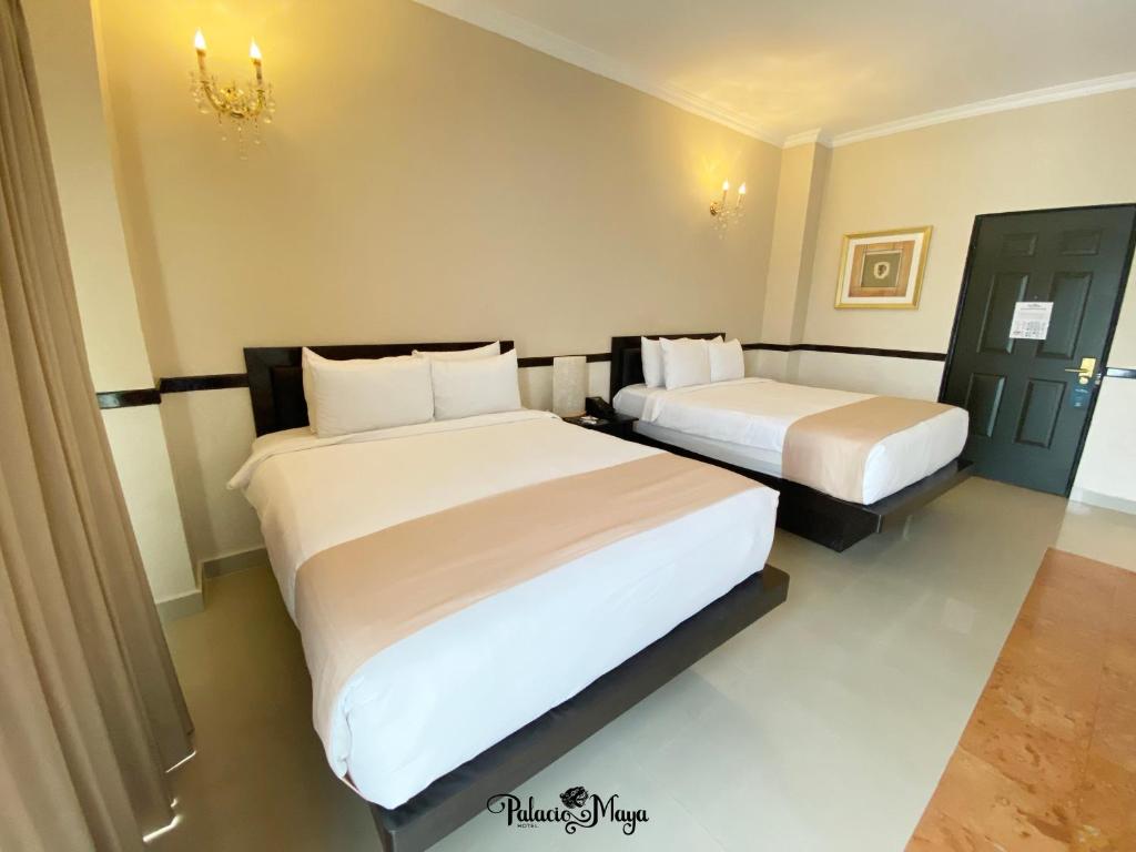 梅里达Hotel Palacio Maya的一间酒店客房,房间内设有两张床