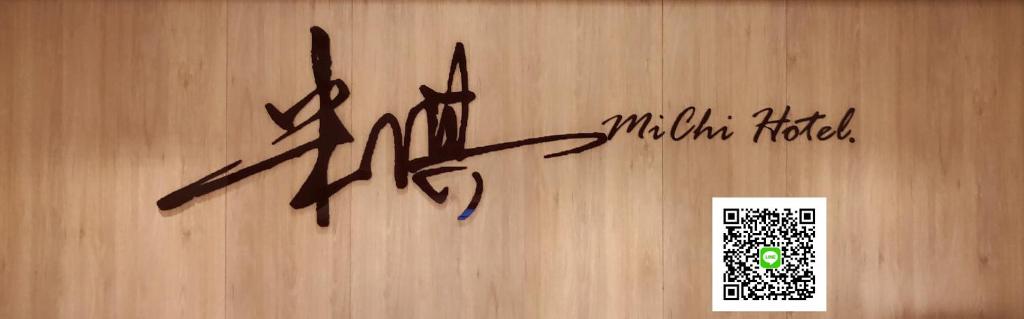 罗东镇米淇旅店 - 罗东馆 的木墙上的标志,上面写着