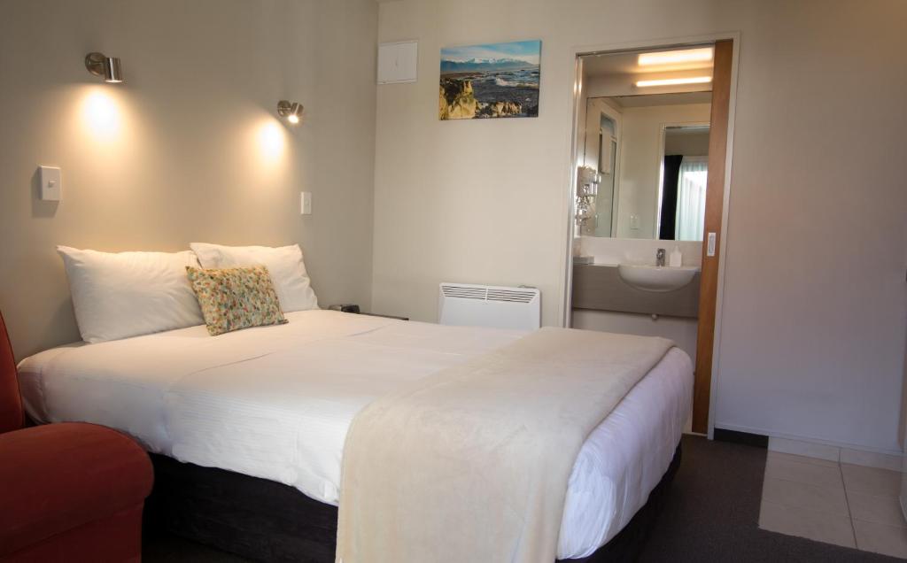 凯库拉凯库拉贝拉维斯特酒店的一间带白色大床的卧室和一间浴室