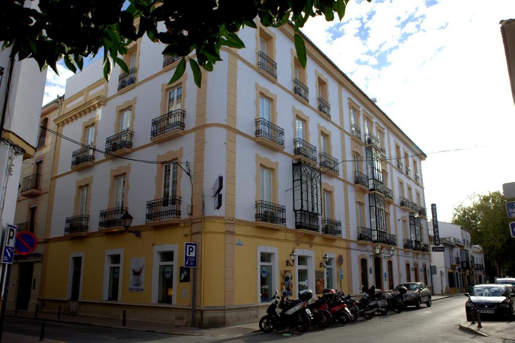 隆达隆达波罗酒店的停在前面的黄色建筑,有摩托车