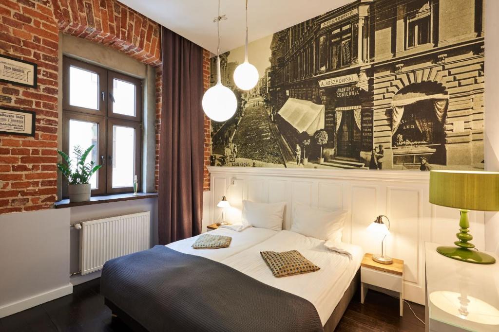 罗兹Apartament Patisserie by Good Time的一间卧室设有一张床和砖墙
