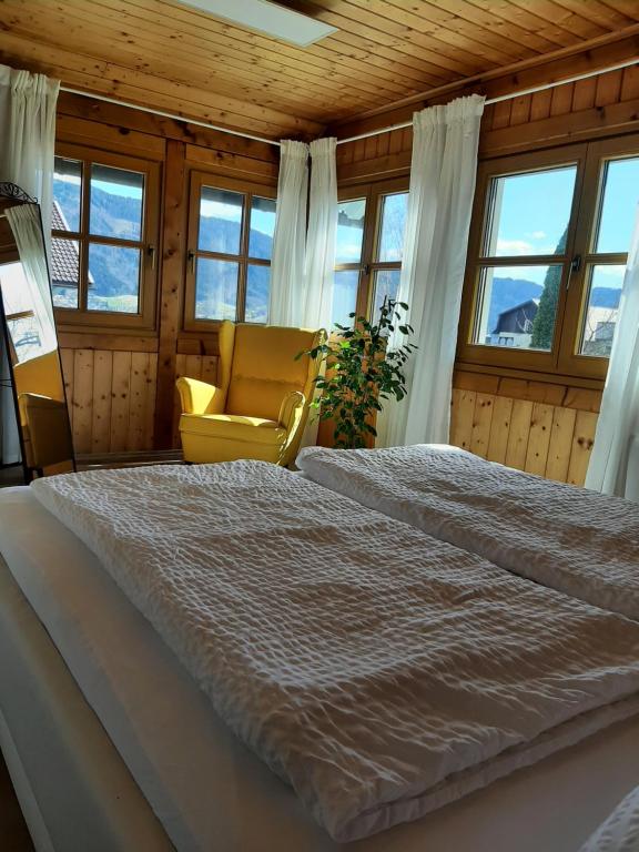 博登斯多夫Ferienwohnung "Marie's Auszeit"的一间卧室配有一张床、一把椅子和窗户。