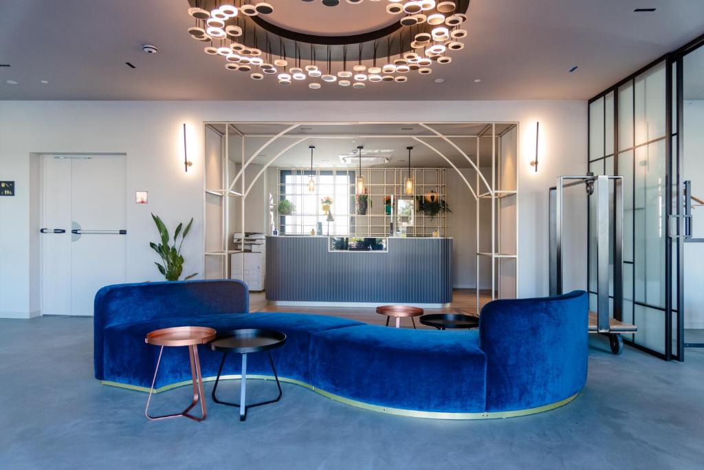 莫迪卡Modica Boutique Hotel的客厅配有蓝色的沙发和桌子