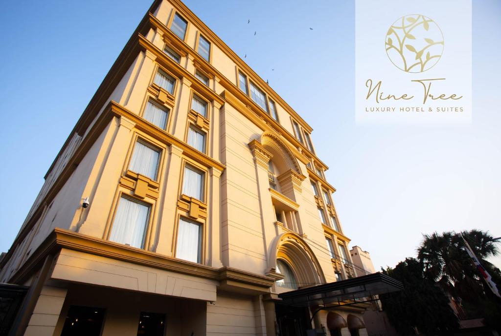 拉合尔Nine Tree Luxury Hotel & Suites Lahore的黄色建筑的侧面设有窗户