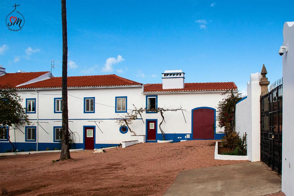 埃尔瓦斯Quinta da Fortaleza的白色的建筑,有红色的门和红色的屋顶
