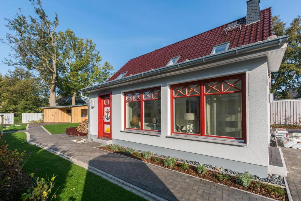 青斯特Buten un Binnen的一座带红色窗户和庭院的房子