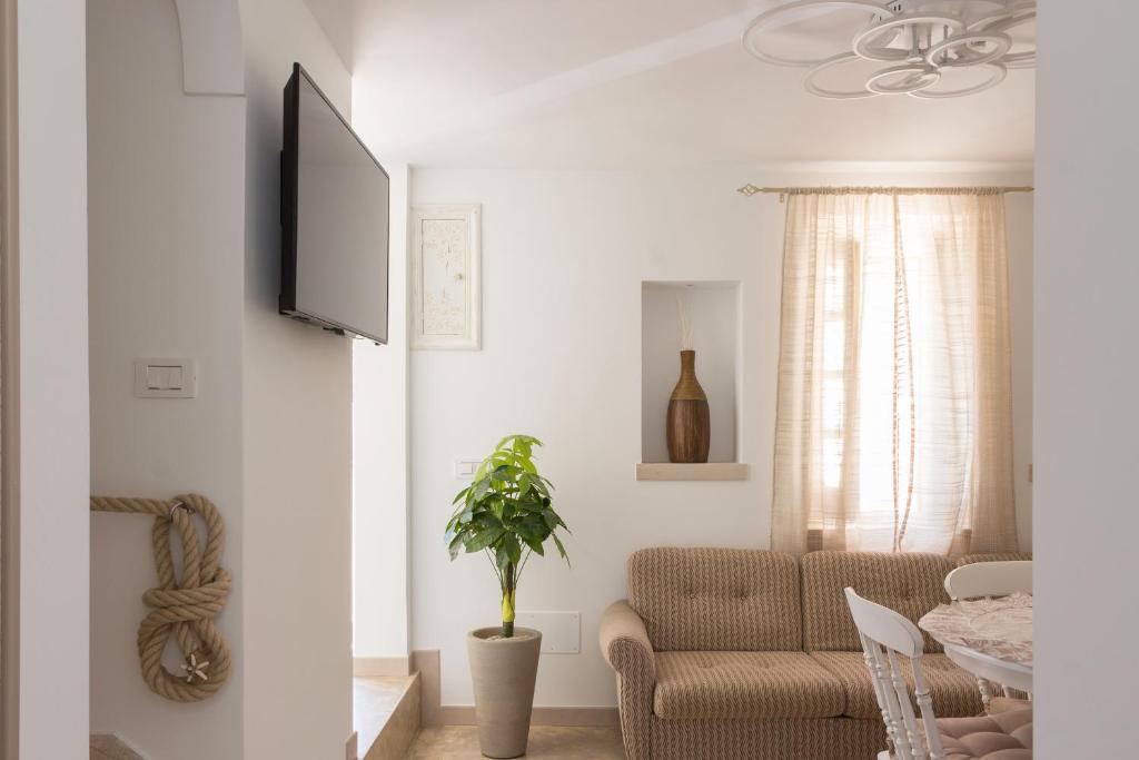 萨维勒特里Stella Bianca的客厅配有沙发和墙上的电视