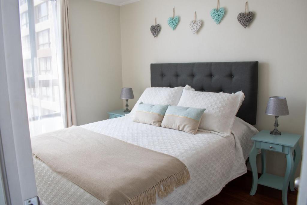 圣地亚哥Sweet Stay Chile的卧室配有白色床和灰色床头板