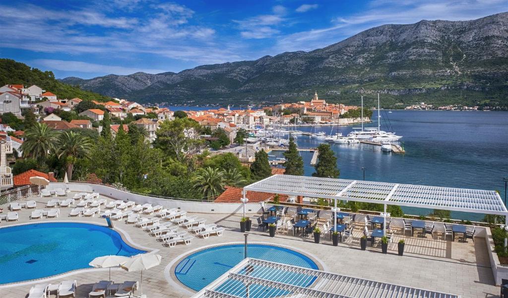 科尔丘拉Marko Polo Hotel by Aminess的享有带游泳池和海港的度假村景色