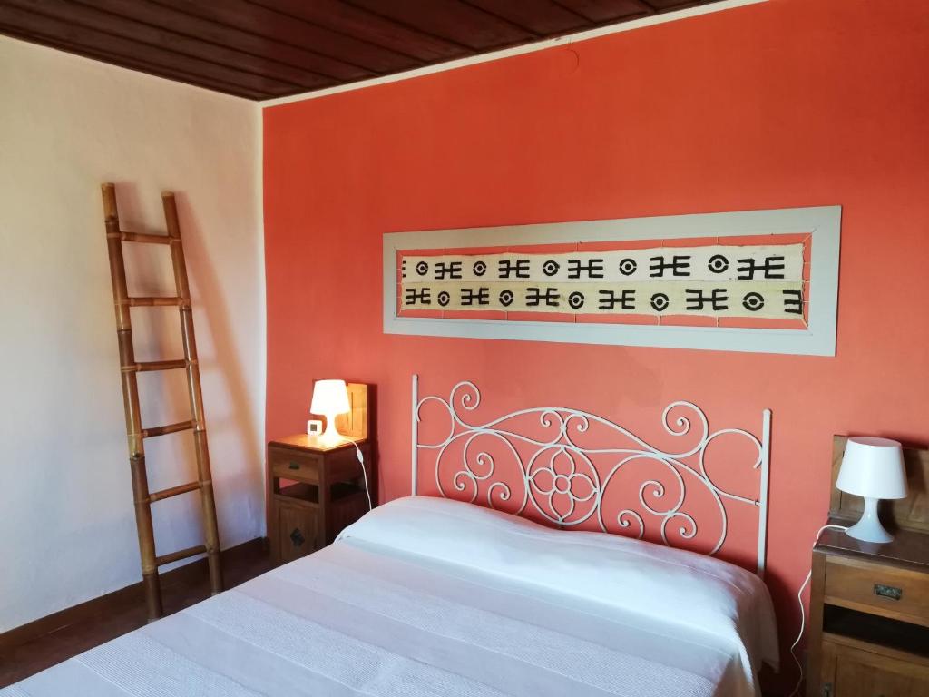 蒙泰卡蒂尼瓦尔迪切奇纳Le civette的一间卧室配有一张橙色墙壁的床
