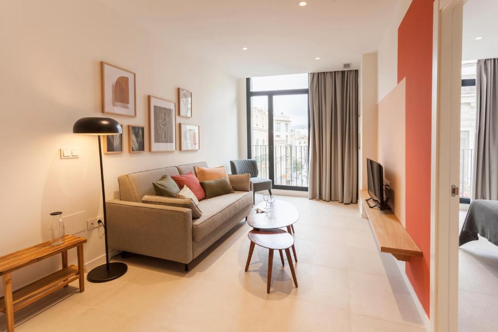 马拉加Apartamentos Málaga Premium - Calle Granada的客厅配有沙发和桌子
