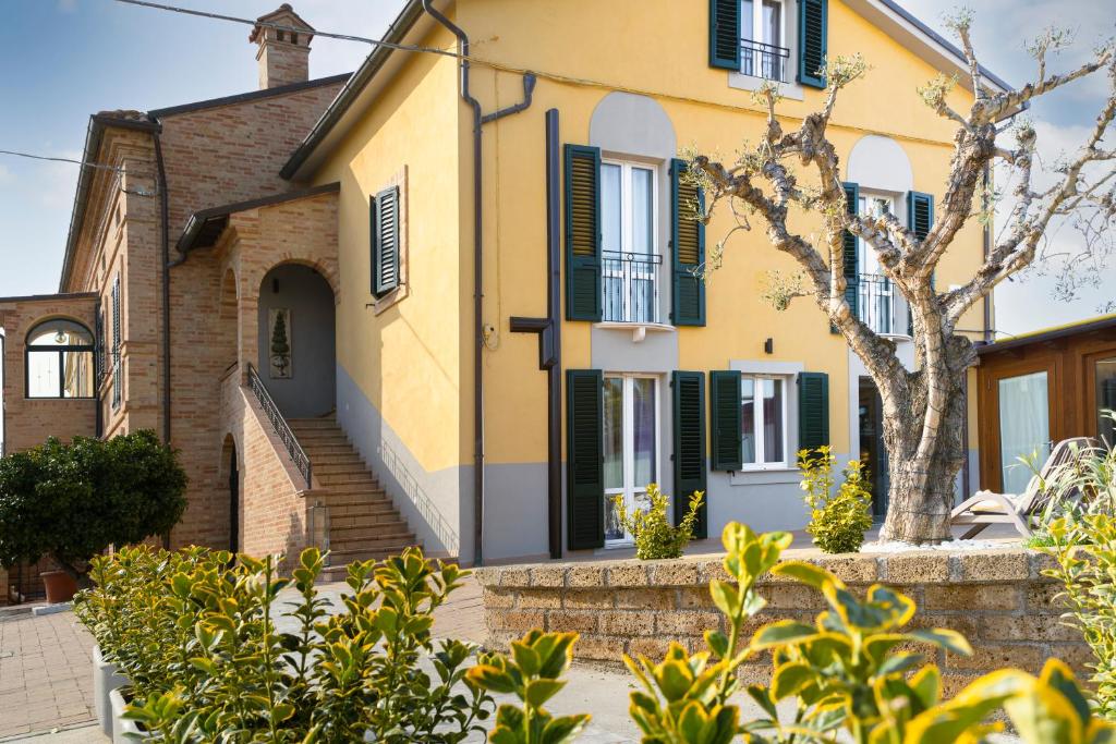 西维尔诺瓦·马尔凯La Locanda dei Cavalieri Country House的黄色的百叶窗度假屋