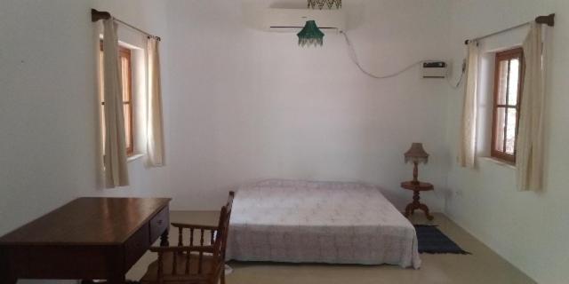 蓬蒂切里Isai Ambalam guest house的一间卧室配有一张床、一张书桌和两个窗户。
