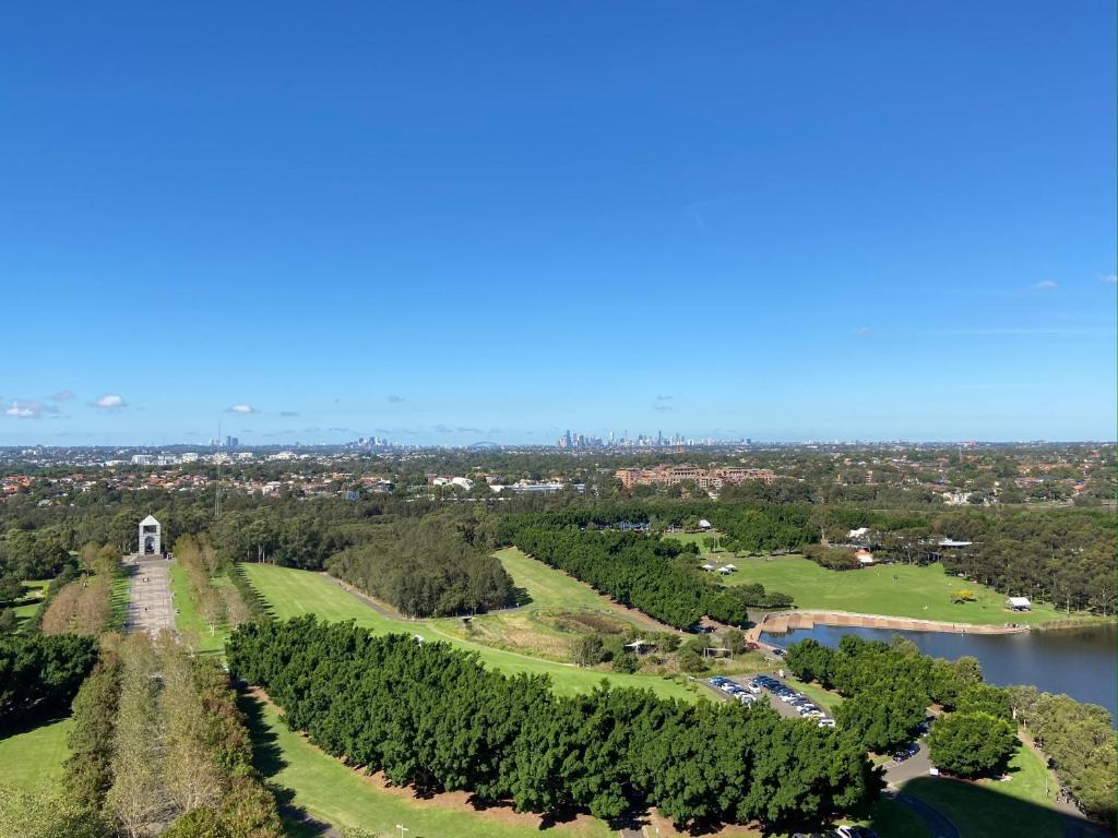 悉尼Park-City view in Sydney Olympic Park的享有公园的空中景致,公园内有河流和树木