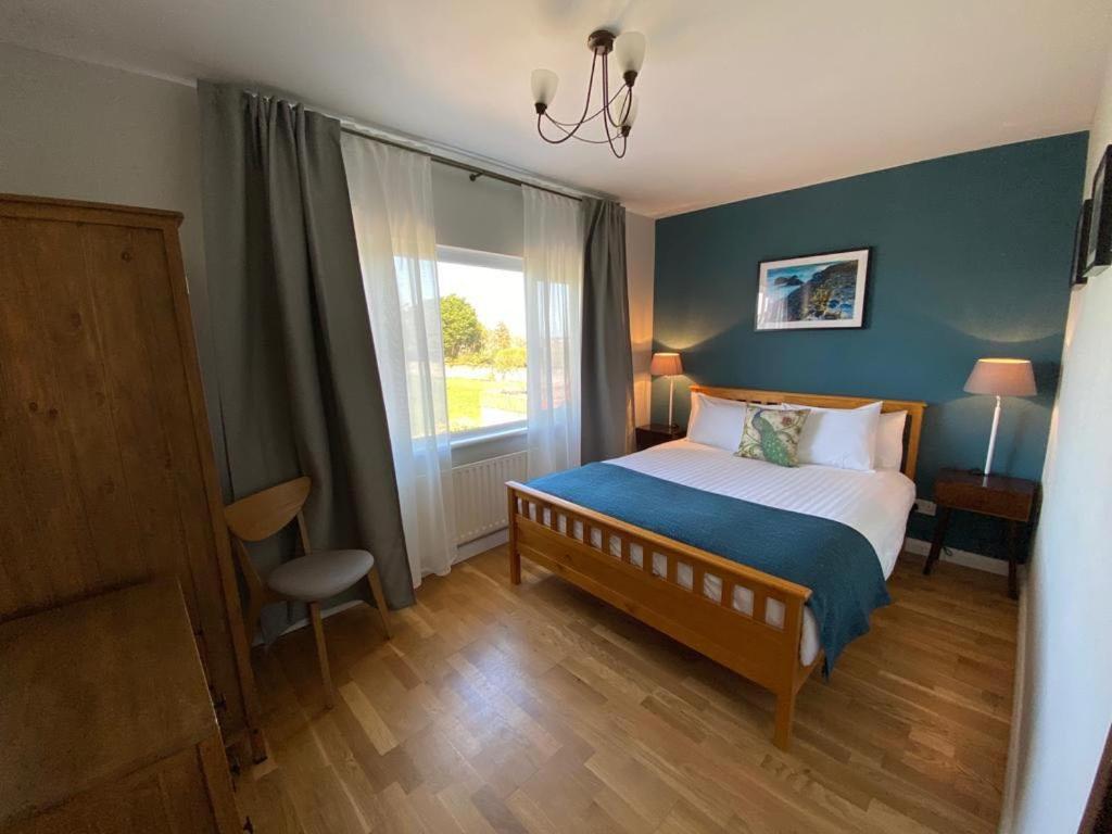 波特拉什Parker House Beach & Golf Portrush的一间卧室设有一张床和一个大窗户