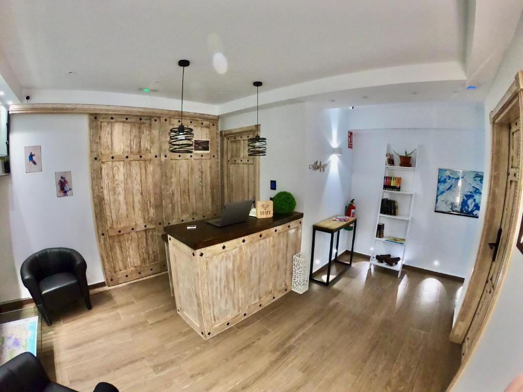皮诺斯赫尼尔El refugio的客厅设有木墙和书桌
