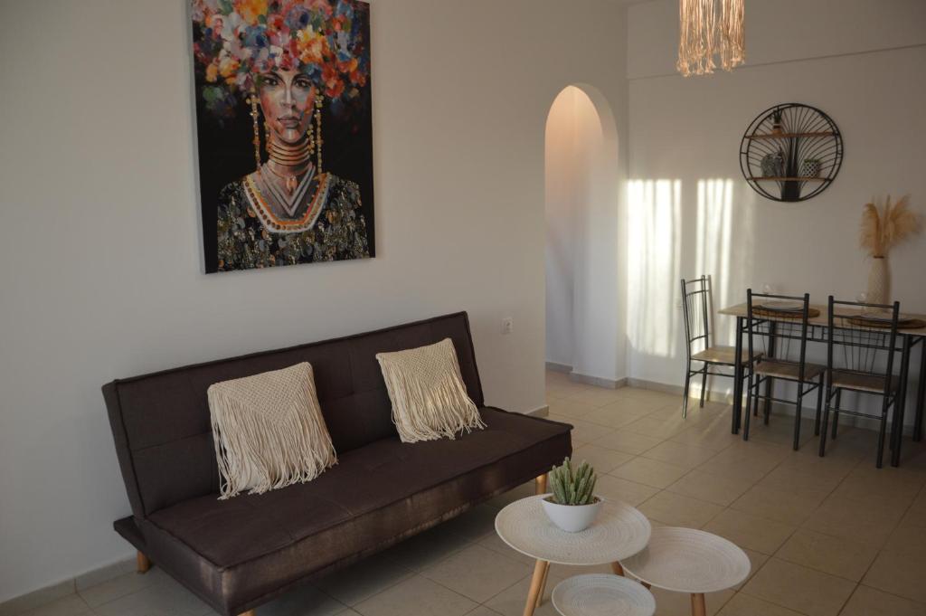 斯泰洛米诺斯Sea melody apartments的客厅配有沙发和墙上的绘画